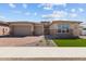 Charming single-story home featuring a brick driveway, three-car garage, and desert landscaping at 1021 W Ridge Rd, Apache Junction, AZ 85120