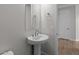 Stylish pedestal sink bathroom with warm wood-look tile flooring at 1042 W Ridge Rd, Apache Junction, AZ 85120
