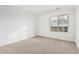 Bright bedroom with neutral carpeting and large window at 18336 W Daley Ln, Surprise, AZ 85387