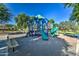 Community playground featuring a climbing structure with slides, swings, and shaded seating areas at 1695 E Mia Ln, Gilbert, AZ 85298