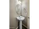 Small powder room featuring a pedestal sink, oval mirror, and neutral wall color at 1695 E Mia Ln, Gilbert, AZ 85298