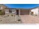 View of house with a two-car garage, desert landscaping, and stone veneer accents at 18792 E Panchito Dr, Gold Canyon, AZ 85118