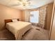 Bright bedroom with carpeted floor, a ceiling fan, and floral curtains at 4065 E University Dr # 503, Mesa, AZ 85205