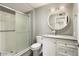 Modern bathroom featuring a shower with sliding glass doors and a vanity with a large round mirror at 11133 W Cameo Dr, Sun City, AZ 85351