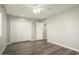 Neutral bedroom featuring wood-look floors, a ceiling fan, and a closet with bi-fold doors at 11133 W Cameo Dr, Sun City, AZ 85351