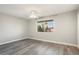 Bright bedroom with wood-look flooring, a ceiling fan, and a window with a view of palm trees at 11133 W Cameo Dr, Sun City, AZ 85351