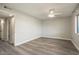 Spacious bedroom featuring wood-look floors, a ceiling fan, and access to an ensuite bathroom at 11133 W Cameo Dr, Sun City, AZ 85351