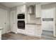 Well-lit kitchen with modern oven and microwave, and white cabinetry at 11133 W Cameo Dr, Sun City, AZ 85351