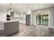Bright kitchen with stainless steel appliances, island with seating, and sliding glass doors to the patio at 11133 W Cameo Dr, Sun City, AZ 85351