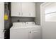 Convenient laundry room with washer, dryer, and built-in storage cabinets at 11133 W Cameo Dr, Sun City, AZ 85351