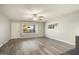 Spacious living room with large window and ceiling fan at 11133 W Cameo Dr, Sun City, AZ 85351