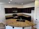 Modern kitchen featuring granite countertops, dark wood cabinets, and stainless steel appliances at 4548 E Carob Dr, Gilbert, AZ 85298