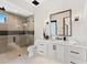 Bright bathroom with a glass shower, toilet, vanity with black hardware, and a large mirror at 9989 E Aleka Way # 337, Scottsdale, AZ 85262