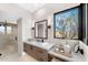 A bright bathroom featuring stone countertops, vanity, a glass shower, and a desert view window at 9989 E Aleka Way # 337, Scottsdale, AZ 85262