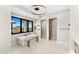 Bright bathroom featuring a soaking tub by large black-trimmed windows, and a modern light fixture at 9989 E Aleka Way # 337, Scottsdale, AZ 85262