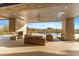 Covered patio with stone fireplace, comfortable seating, and views of the pool and surrounding desert landscape at 9989 E Aleka Way # 337, Scottsdale, AZ 85262