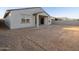 Home's back exterior with covered patio and sandy backyard at 37034 W La Paz St, Maricopa, AZ 85138