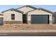 Newly built home with gray exterior, dark garage door, and stone accents at 4314 W Josephine St, San Tan Valley, AZ 85144