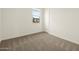 Bright bedroom featuring plush carpeting, a window and a door with white trim, ready for personal touches at 4937 W Hunter Trl, San Tan Valley, AZ 85144