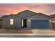 Charming single-story home featuring a blue garage door, a modern gray exterior and low-maintenance desert landscaping at 4937 W Hunter Trl, San Tan Valley, AZ 85144