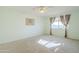 Comfortable bedroom includes carpet, light, art and a window with patterned curtains at 12442 W Marble Dr, Sun City West, AZ 85375