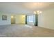 Inviting living room featuring a large window with curtains and a stylish chandelier at 12442 W Marble Dr, Sun City West, AZ 85375