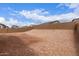 Backyard featuring an unfinished dirt lot with a block fence surround and a view of neighborhood homes at 18650 E Panchito Dr, Gold Canyon, AZ 85118