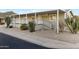 Charming mobile home featuring an extended awning, front porch, xeriscaped yard, and desert landscaping at 2233 E Behrend Dr # 132, Phoenix, AZ 85024