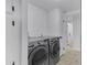 Well-lit laundry room area with gray washer and dryer machines, white walls, and light wood-look floors at 2233 E Behrend Dr # 132, Phoenix, AZ 85024