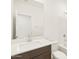 Bathroom with a large mirror, white counter, dark wood cabinet, and a toilet near a shower-tub combo at 16017 W Cottontail Ln, Surprise, AZ 85387