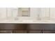 Modern double sink vanity with white countertop and dark cabinets at 16017 W Cottontail Ln, Surprise, AZ 85387