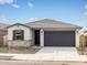 Charming single-story home with a two-car garage, stone accents, and desert landscaping at 16017 W Cottontail Ln, Surprise, AZ 85387