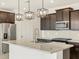 Modern kitchen featuring stainless steel appliances, dark cabinets, and a spacious island at 16017 W Cottontail Ln, Surprise, AZ 85387