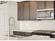 Close up of a modern kitchen with stainless steel appliances and mosaic tile backsplash at 16017 W Cottontail Ln, Surprise, AZ 85387