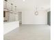 Open-concept kitchen and living area with white walls, wood-look tile floors, and pendant lighting at 16017 W Cottontail Ln, Surprise, AZ 85387