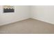 Bright bedroom with neutral carpeting and a window providing natural light and views at 16082 W Desert Spoon Dr, Surprise, AZ 85387