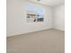 Carpeted bedroom featuring a large window and neutral walls at 16082 W Desert Spoon Dr, Surprise, AZ 85387
