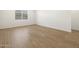 Minimalist bedroom featuring a large window, neutral paint, and wood-look flooring at 16082 W Desert Spoon Dr, Surprise, AZ 85387