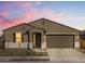 Inviting home exterior featuring a neutral color scheme under a colorful sky at 16082 W Desert Spoon Dr, Surprise, AZ 85387
