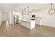 Open-concept kitchen boasts white cabinetry, stainless steel appliances, and a large island with pendant lighting at 16082 W Desert Spoon Dr, Surprise, AZ 85387