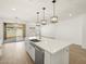 Bright, modern kitchen featuring a quartz island countertop, stainless steel appliances, and contemporary pendant lighting at 16082 W Desert Spoon Dr, Surprise, AZ 85387