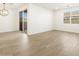 Bright living room with wood floors and a sliding glass door to the backyard at 16082 W Desert Spoon Dr, Surprise, AZ 85387