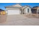 Charming one-story home with white exterior, stone accents, and a two-car garage at 40000 W Bunker Dr, Maricopa, AZ 85138