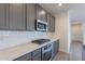 Modern kitchen with gray cabinets, white subway tile backsplash, and stainless steel appliances at 40000 W Bunker Dr, Maricopa, AZ 85138