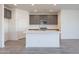 Modern kitchen with gray cabinets and a large island with white quartz countertops at 40000 W Bunker Dr, Maricopa, AZ 85138