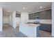 Modern kitchen with gray cabinets and a large island with white quartz countertops at 40000 W Bunker Dr, Maricopa, AZ 85138