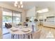 Bright dining area with modern light fixture, leading to a patio for seamless indoor-outdoor living, complemented by the adjacent kitchen at 9902 W Sandstone Dr, Sun City, AZ 85351