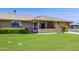 Charming single-story home with a well-maintained lawn and inviting front porch, situated on a sunny corner lot at 9902 W Sandstone Dr, Sun City, AZ 85351