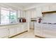 Traditional kitchen with white cabinets and modern appliances at 9902 W Sandstone Dr, Sun City, AZ 85351