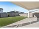 Covered patio with spacious backyard featuring low-maintenance artificial grass, desert landscaping, and block wall fence at 10155 E Toledo Ave, Mesa, AZ 85212